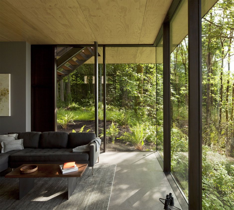 Living room with panoramic windows in the forest